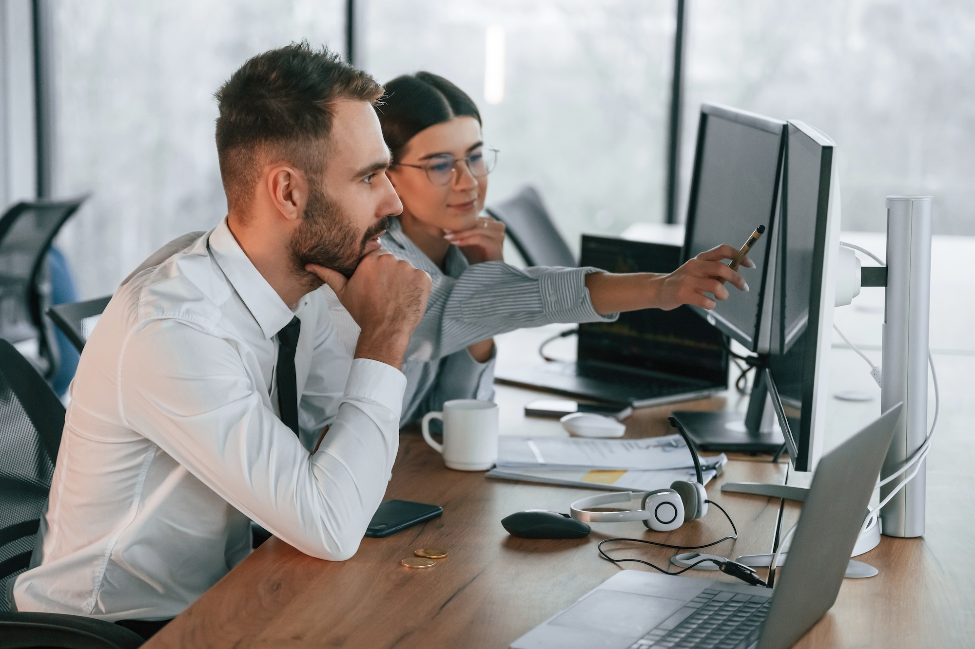 Two people looking at computer screens in an office