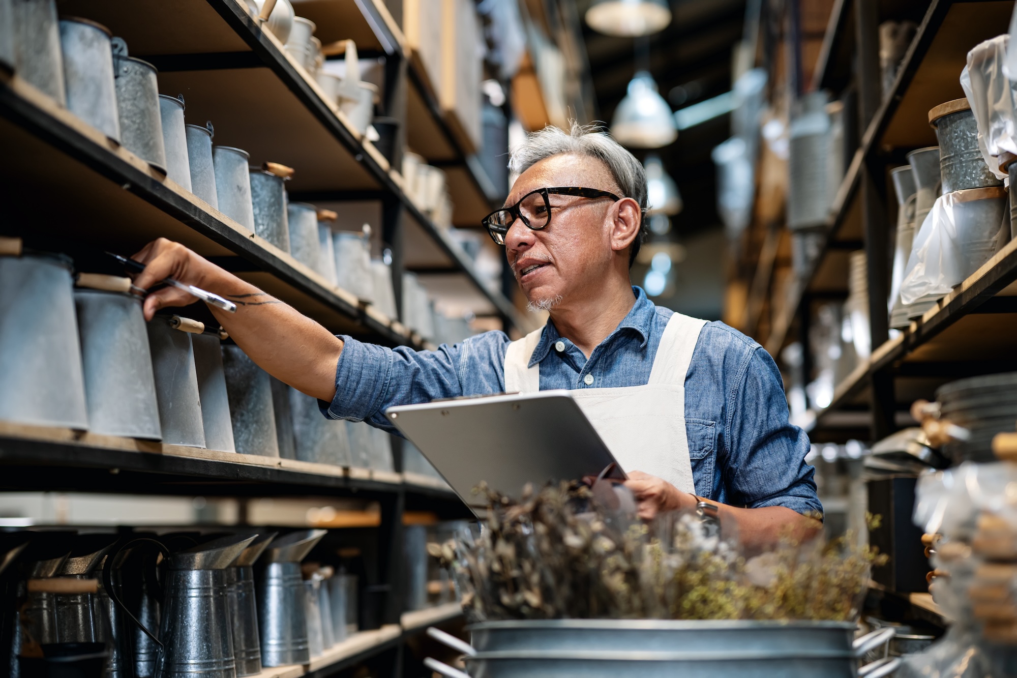 A man taking stock of pottery items in a warehouse