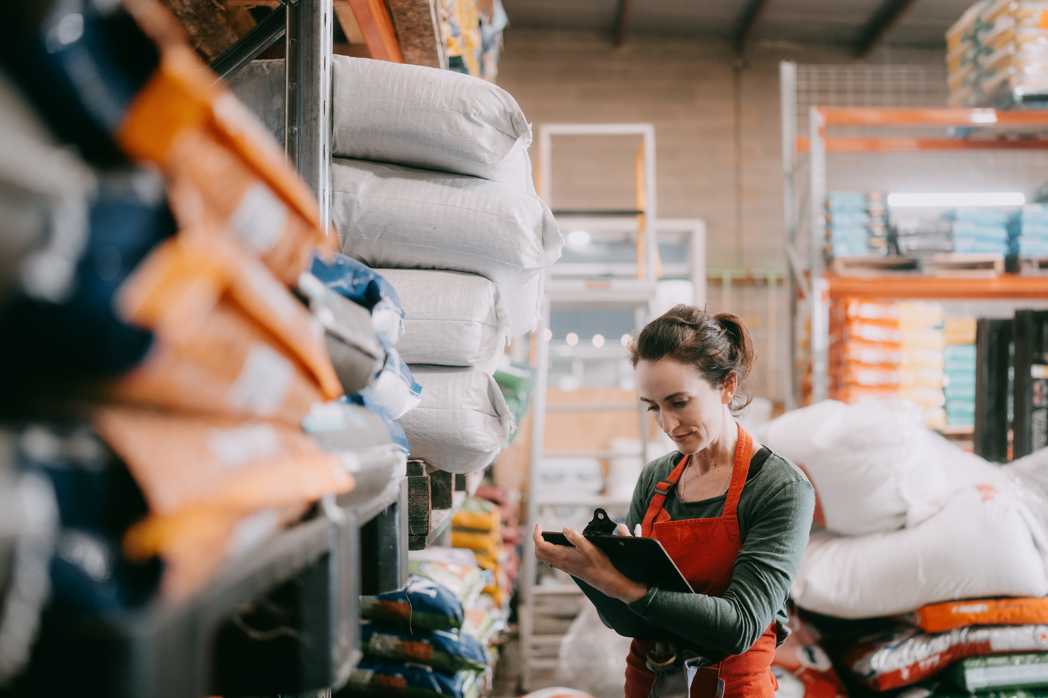 A woman is taking stock in a warehouse