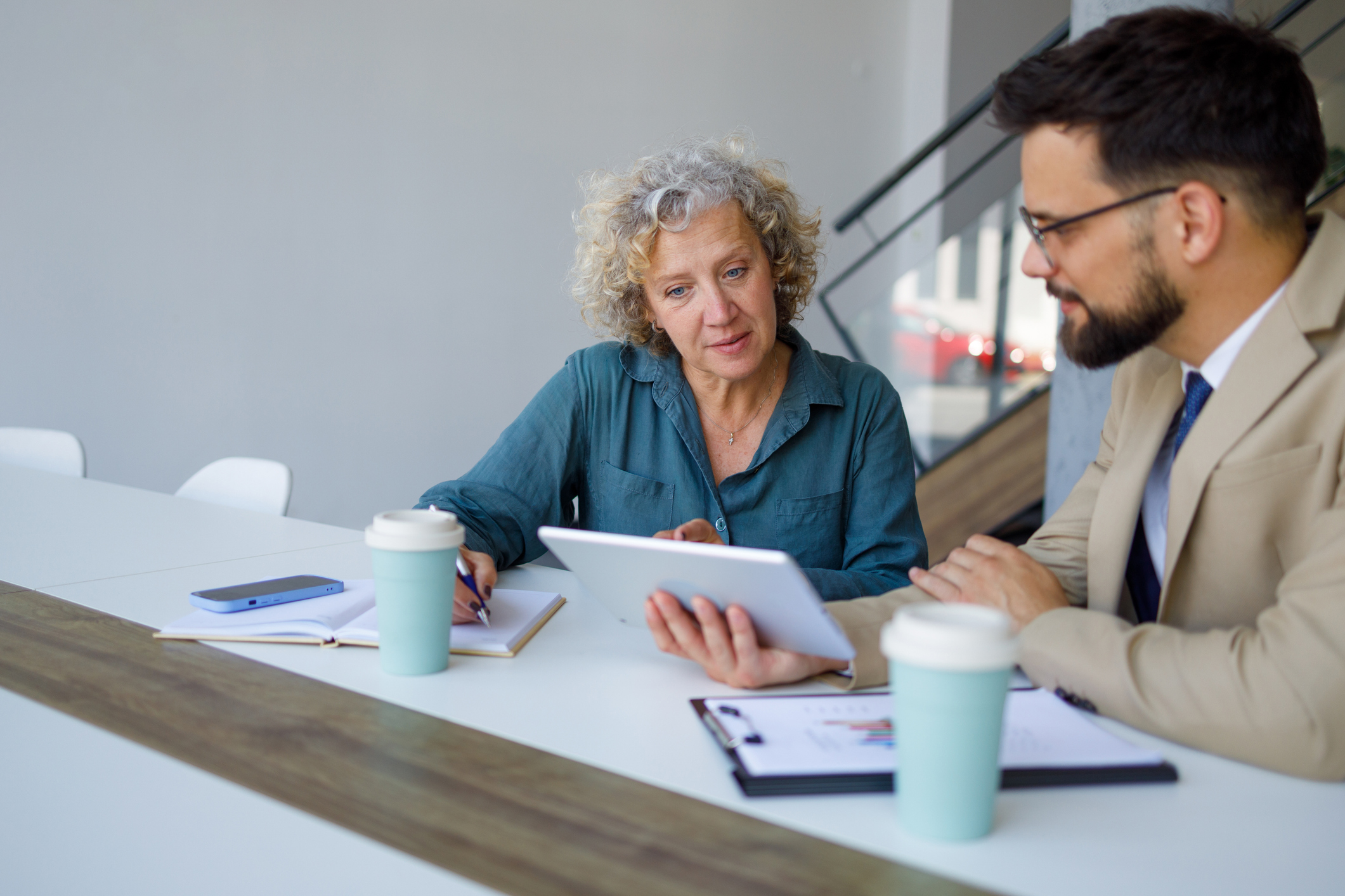 Two people reviewing a report on a tablet