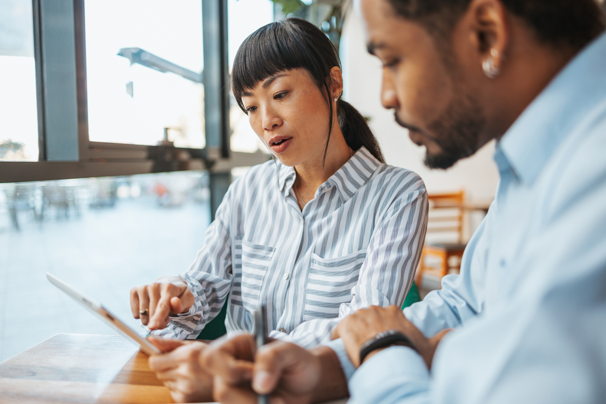 Two people looking at a report on a tablet