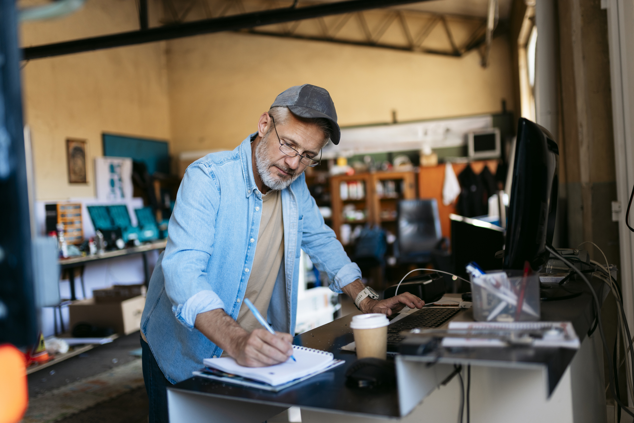 A man writing notes in a workshop