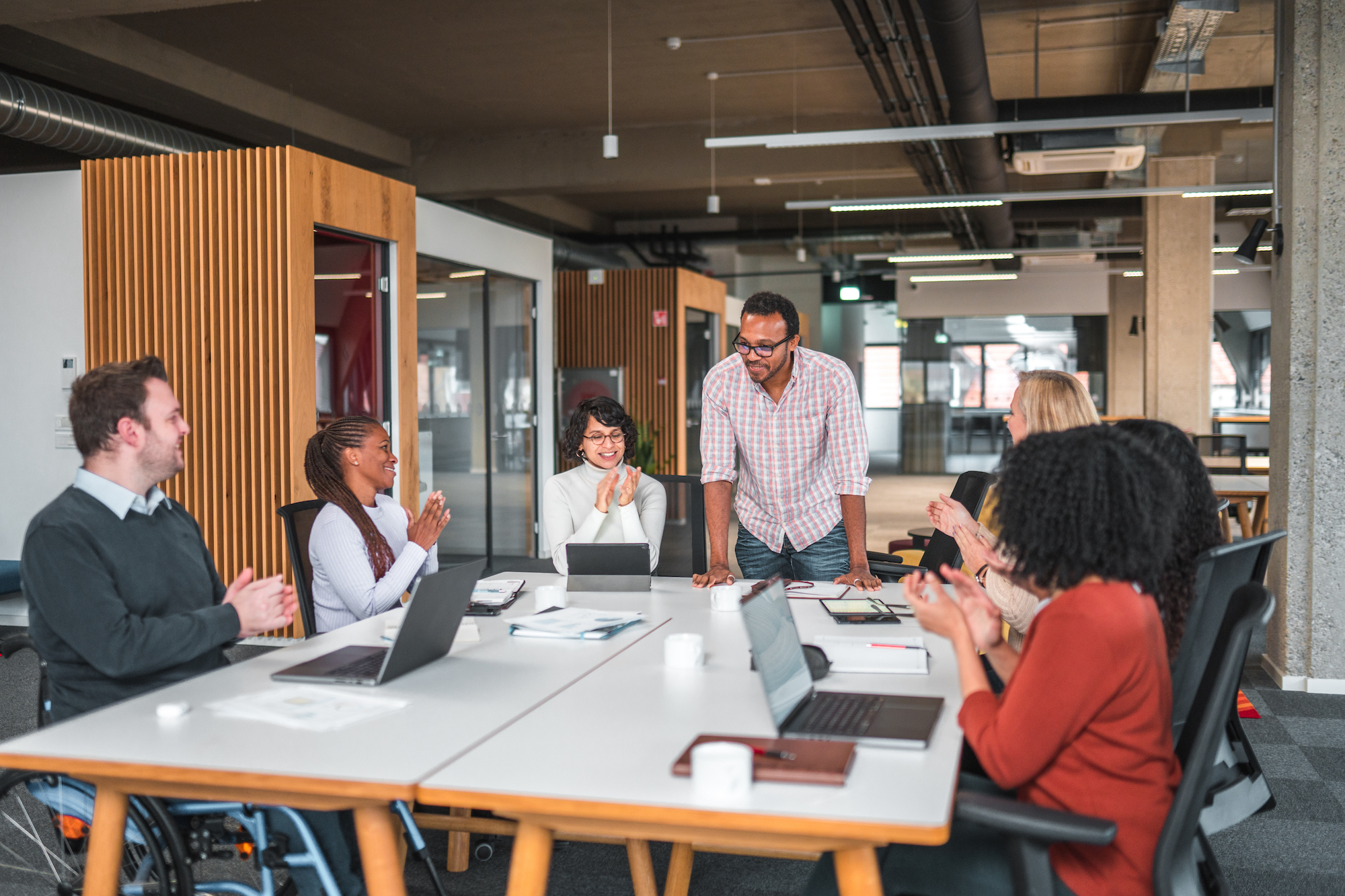 A group of young professionals talking around a large table.