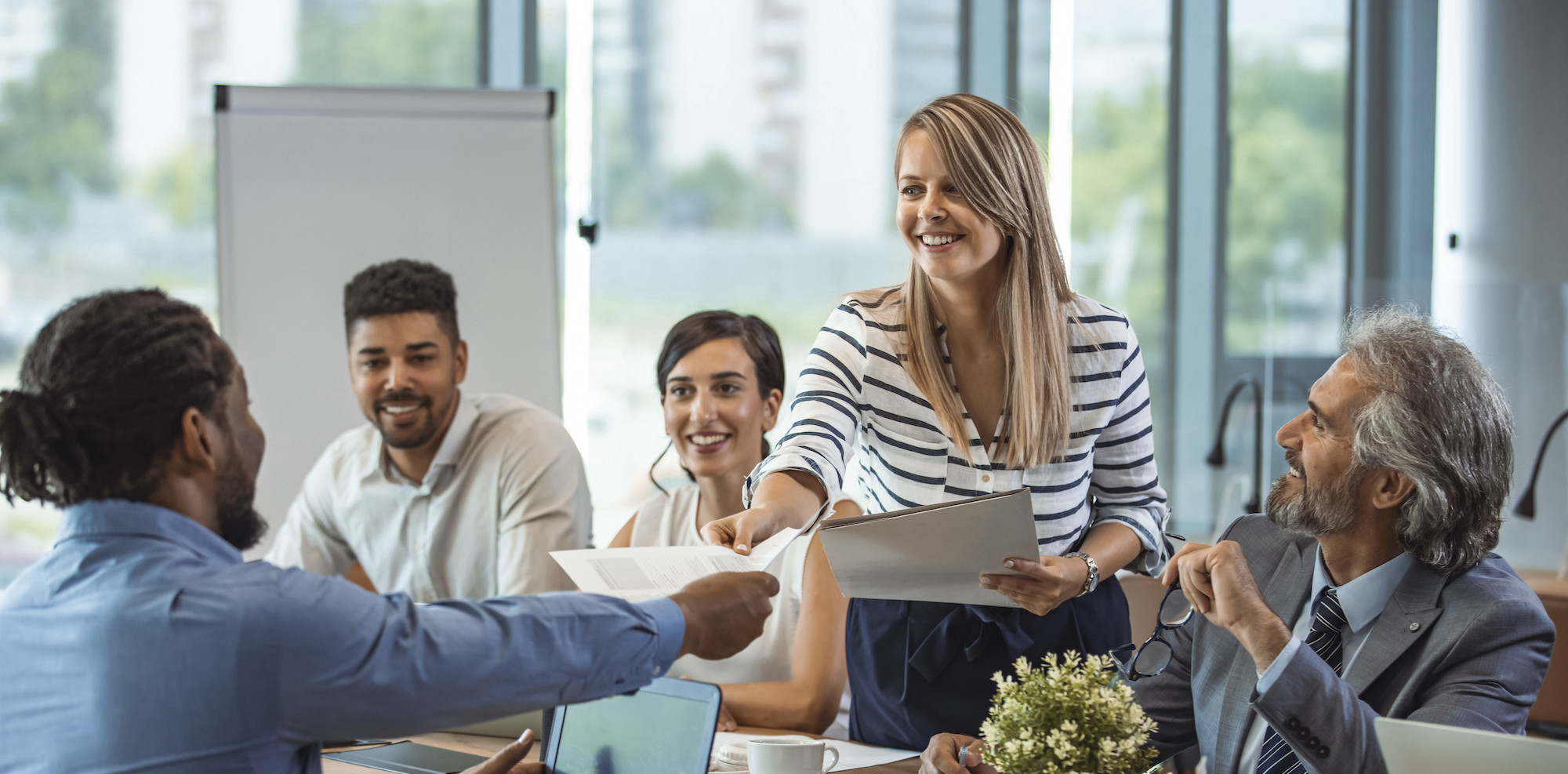 A group of office workers sitting around a table talking about a project.